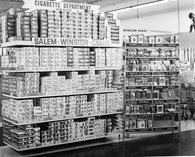A display of tobacco cigarettes in a grocery store. Signs read &quot;Cigarette Department&quot; and Salem-Winston-Camel.&quot;