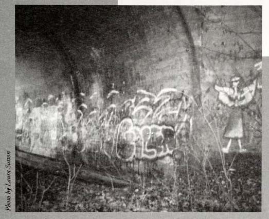 &quot;Lydia is Here.&quot; Photograph of drawing of angel and graffiti in the underpass to the abandoned bridge near E. Main Street in Jamestown, North Carolina. The ghost &quot;Lydia&quot; is believed to haunt the site.  Image from the North Carolina Folklore Journal, Midwinter 2000.