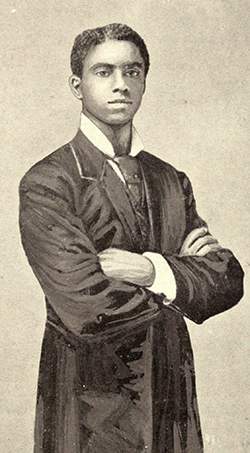 Young Merrick. He stands arm crossed, with a stoic expression. He wears a long, formal coat.