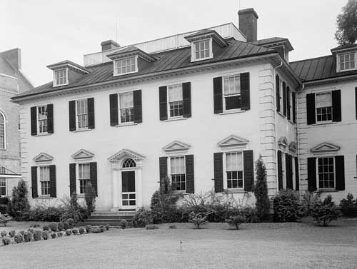 A large, federal style home. Two stories, with many windows and roof dorners.