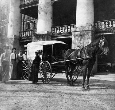 &quot;View of Dughi's Ice Cream cart parked in from of the main building at Peace College with young women around the cart. Horse pulling cart is likely Nancy. Raleigh, NC, c.1900-1910's. From the Dughi Family Photo Collection, PhC.166, North Carolina State Archives, Raleigh, NC, call #: PhC_166_9. 