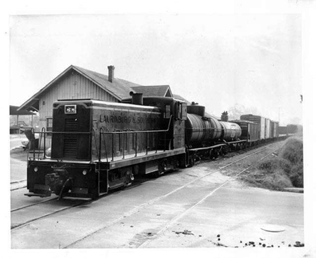 A train on rails crossing a road.