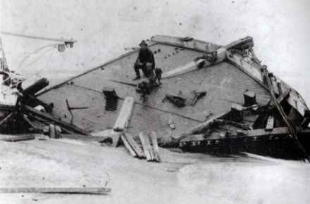 The Priscilla wrecked during the hurricane of 1899. Rasmus Midgett, sitting on the wreckage, saved ten people from the ship during the hurricane. Image courtesy of the NC Office of Archives and History via East Carolina University.