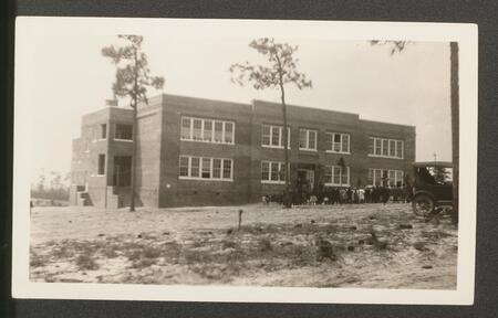 A large group of students in front of a large brick school building