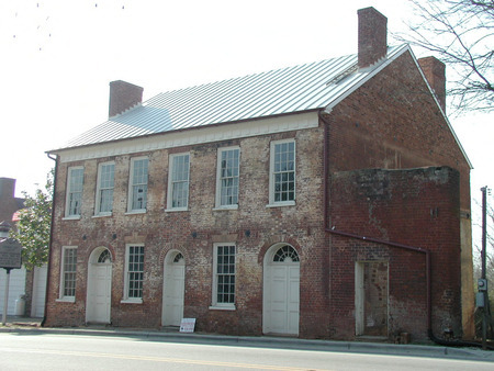 A two story brick building with several chimneys