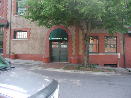 A green awning over two green doors that are the entrance to the Asheville NC YMI Cultural Center