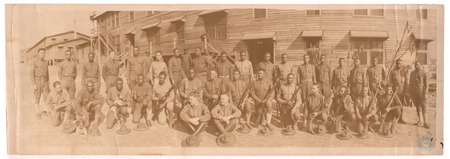 Black men in uniform two rows stand or kneel with rifles while two white men in uniform sit in front