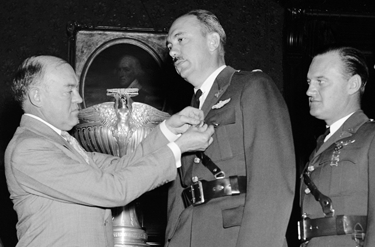 War Secretary Harry H. Woodring (left) pins medals on Carl J. Crane (center) and George V. Holloman (right). Harris & Ewing. &quot;War Secretary presents Army Flyers with Mackay Trophy. Washington, D.C., Oct. 14. As a reward for their development and demonstration of the original automatic landing device for aircraft, Captains Carl J. Crane and George V. Holloman, U.S. Army Air Corps, were today presented with the MacKay trophy for 1937 by Secretary of War Harry H. Woodring. Gold medals, emblematic of the trophy were presented the Flyers at the same time. Left to right: Charles F. Horner, Chairman of the National Aeronautic Association; Secretary Woodring, Capt. Carl J. Crane, and Capt. George V. Holloman, 10/14/38&quot;. Photograph. [19]38 October 14. LC-H22-D- 4701. Prints and Photographs Division, Library of Congress.