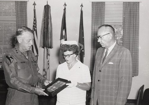 &quot;LTG John J. Tolson, Commanding General XVIII Corps, presents the Silver Star and Bronze Medal posthumously to Glanor Gay Best and Hugh Best Jr., who are receiving the medals on behalf of their deceased son, Hugh E. Best III, who was killed in action in 1969 in the Vietnam War,&quot; by C. Gene Tyree DAC at Fort Bragg, North Carolina, published in 1969. Image is presented on East Carolina University's Digital Collection.