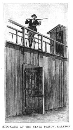 A man walks across a large wooden wall. He his carrying a cane. 